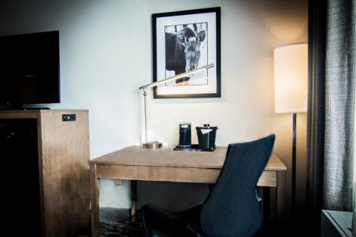 einen Schreibtisch in einem Hotelzimmer mit einem blauen Stuhl in der Unterkunft La Quinta by Wyndham Anchorage Airport in Anchorage
