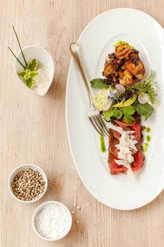 a plate of food with a salad and a fork at Hotel Landhaus Wachtelhof in Rotenburg an der Wümme