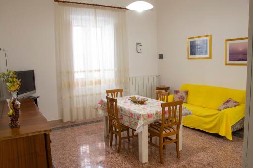 a living room with a table and a yellow couch at Casa Vacanze Maria&Vito in Veglie