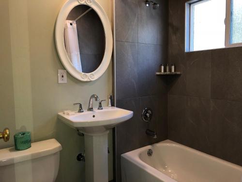 a bathroom with a sink and a mirror and a tub at Hotel Elevation in South Lake Tahoe