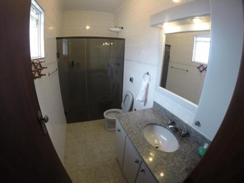 Confortável casa de madeira في بوكوس دي كالداس: حمام مع حوض ودش ومرحاض