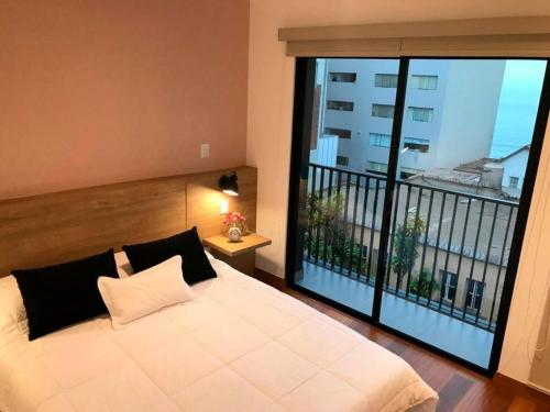 a bedroom with a white bed and a large window at MLA apartments - Buenos Aires in Lima