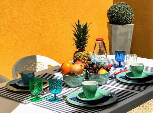 una mesa con tazones de fruta y tazas. en Passadiços da Ria, en Aveiro