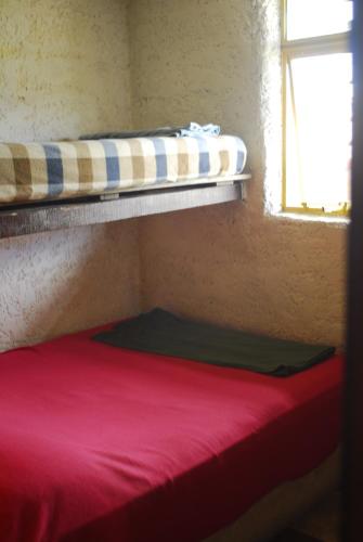 a room with two bunk beds and a red mattress at Viejo Lobo in Cabo Polonio