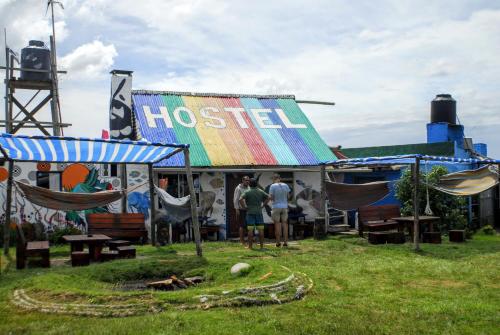 a group of people standing outside a hostel with hammocks at Viejo Lobo in Cabo Polonio
