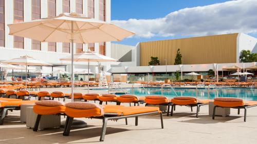 a group of chairs and an umbrella next to a pool at Grand Sierra Resort and Casino in Reno
