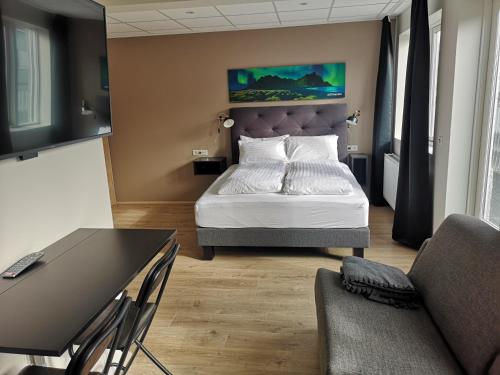 a bedroom with a bed and a table and chairs at Centrum Hotel in Akureyri