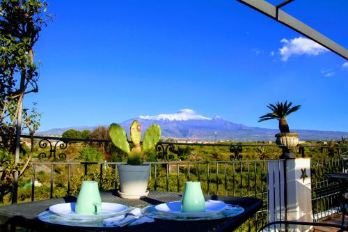 einen Tisch mit 2 Tellern und Bergblick in der Unterkunft Palazzo Giovanni bed and breakfast in Acireale