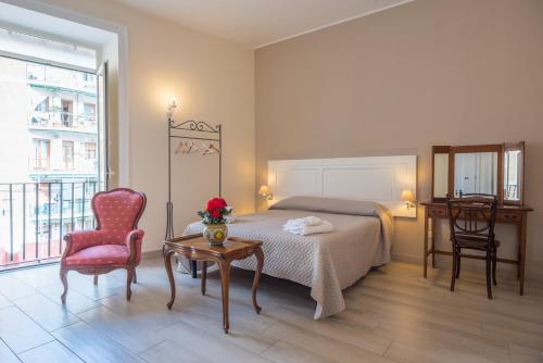 a bedroom with a bed and a table and a chair at B&B Supportico Lopez in Naples