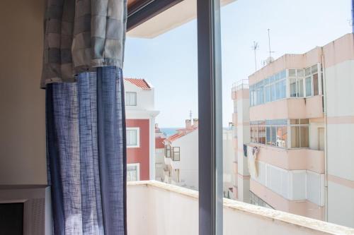 a window with a view of a city at Home By The Sea in Sesimbra