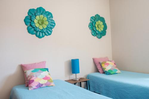 two beds in a room with blue and green decorations at Home By The Sea in Sesimbra
