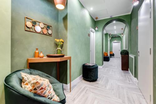 un couloir avec des murs verts, un canapé et une table dans l'établissement Ripetta Luxurious Suites, à Rome