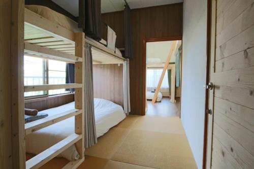a room with bunk beds and a bedroom with a door at 晴家(HALELUYA) Guest House in Fujikawaguchiko