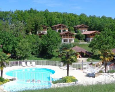 uma vista para um resort com uma piscina em Chalet Cahors - 4 pers. em Mauroux