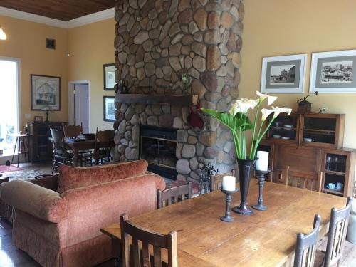a living room with a table and a stone fireplace at Pescadero Creek Inn in Pescadero