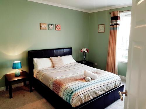 um quarto com uma cama grande e uma janela em Three Bed Holiday Home in Glasgow em Glasgow