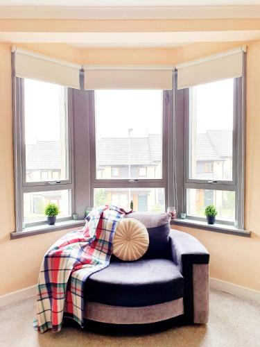una camera da letto con un letto e due finestre di Three Bed Holiday Home in Glasgow a Glasgow