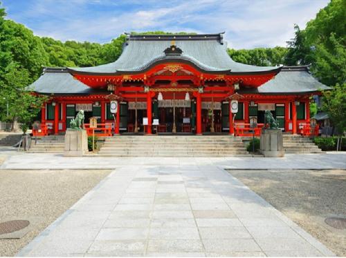 a pagoda with a red building in a park at Y's HOTEL Hanshin Amagasaki Ekimae in Amagasaki