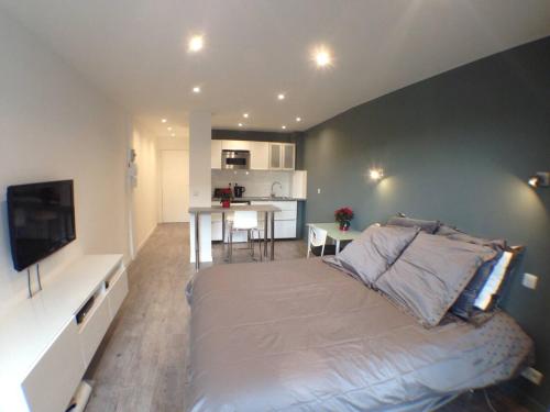 une chambre avec un grand lit et une cuisine dans l'établissement Studio flambant neuf, calme & balcon, à Strasbourg