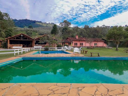 una imagen de una casa con piscina en Fazenda Serra que Chora - Pousada e Restaurante, en Itanhandu