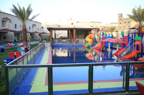 a pool with a water park with a water slide at Al Khuzama Resort in Taif