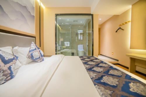 a hotel room with a bed and a bathroom at Demei Boutique Hotel in Kunming