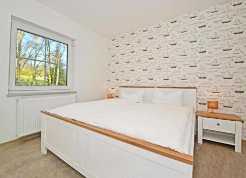 a bedroom with a large white bed and a window at Villa Doris Bng 8 Hanau in Heringsdorf