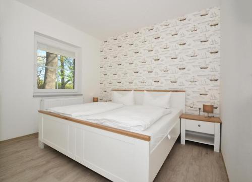 - une chambre blanche avec un lit et une fenêtre dans l'établissement Villa Doris Bng 9 Auritz, à Heringsdorf