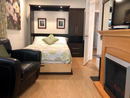 um quarto com uma cama, um sofá e uma lareira em Gibsons Harbour Retreat em Gibsons