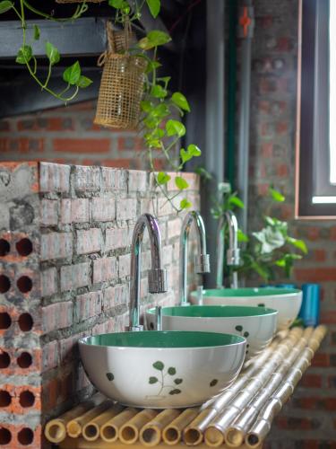 a row of sinks on a brick wall at Halo Bay Homestay in Ha Long
