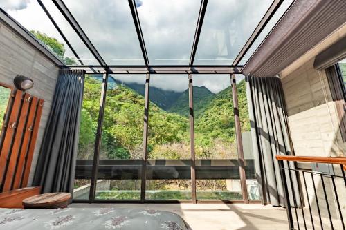 a room with a large window with a mountain view at Echovilla B&B II in Hualien City