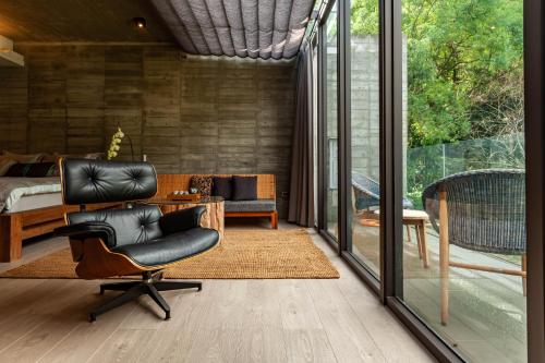 a living room with a chair and a bedroom at Echovilla B&B II in Hualien City