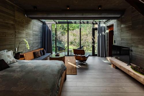 a bedroom with a bed and a living room with a fireplace at Echovilla B&B II in Hualien City
