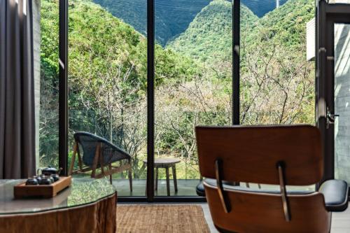 a room with a table and chairs and a large window at Echovilla B&B II in Hualien City