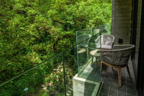 a chair and a table on a glass balcony at Echovilla B&B II in Hualien City