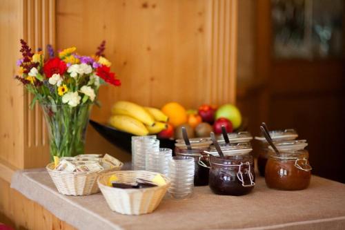 a table with a vase of flowers and fruit at Pension Schierl in Faistenau