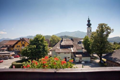 a view of a town with a church and flowers at Pension Schierl in Faistenau