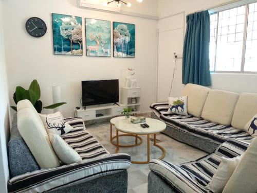 a living room with two couches and a tv at D'Rusa Homestay in Port Dickson