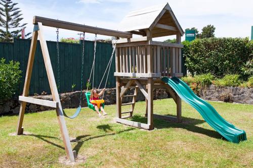 a childrens playground with a swing and a tower at Accommodation at Te Puna Motel in Tauranga