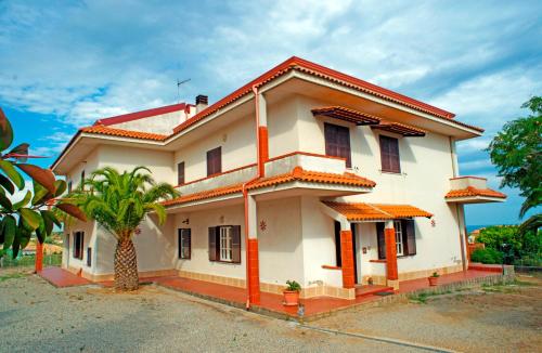 a white house with a palm tree in front of it at La Casa Di Mirò in Catanzaro Lido