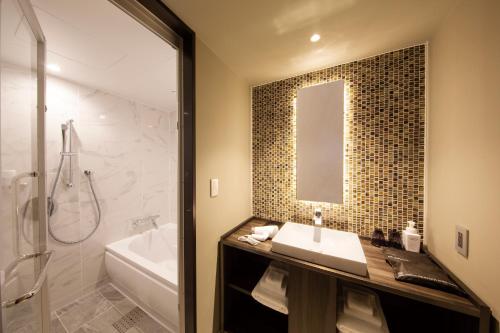 a bathroom with a tub, sink, and shower at Shibuya Stream Excel Hotel Tokyu in Tokyo