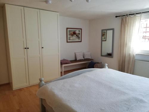 a bedroom with a white bed and a window at Ferienwohnung-Hallebach in Zell an der Mosel