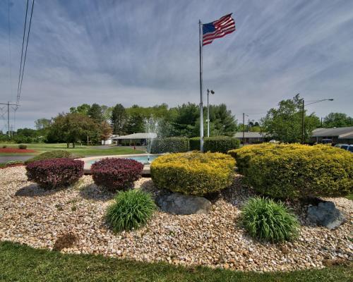 an american flag flying over a garden with bushes at Parkview Inn and Conference Center in Allentown