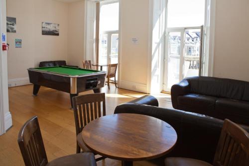 a living room with a couch and a pool table at Berties Lodge in Newquay