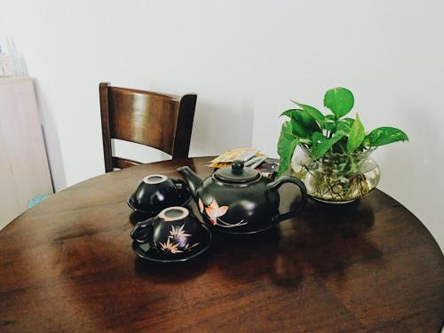 會安的住宿－Xanh Lá Homestay Hội An，一张木桌,上面有两个茶壶和植物