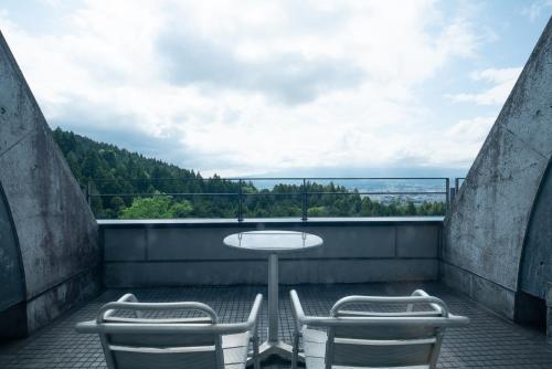 a table and two chairs on a balcony with a view at Rembrandt Premium Fuji Gotenba in Gotemba