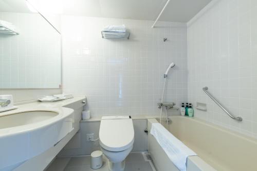 a bathroom with a toilet and a sink and a tub at Rembrandt Premium Fuji Gotenba in Gotemba