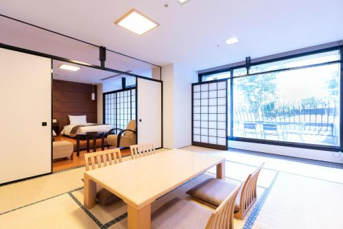 a dining room with a table and chairs and a bedroom at Rembrandt Premium Fuji Gotenba in Gotemba