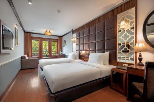 a hotel room with two beds and a couch at Classy Holiday Hotel & Spa in Hanoi