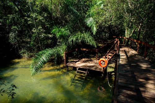 a wooden bench sitting in a stream of water at Pousada Boyrá in Bonito